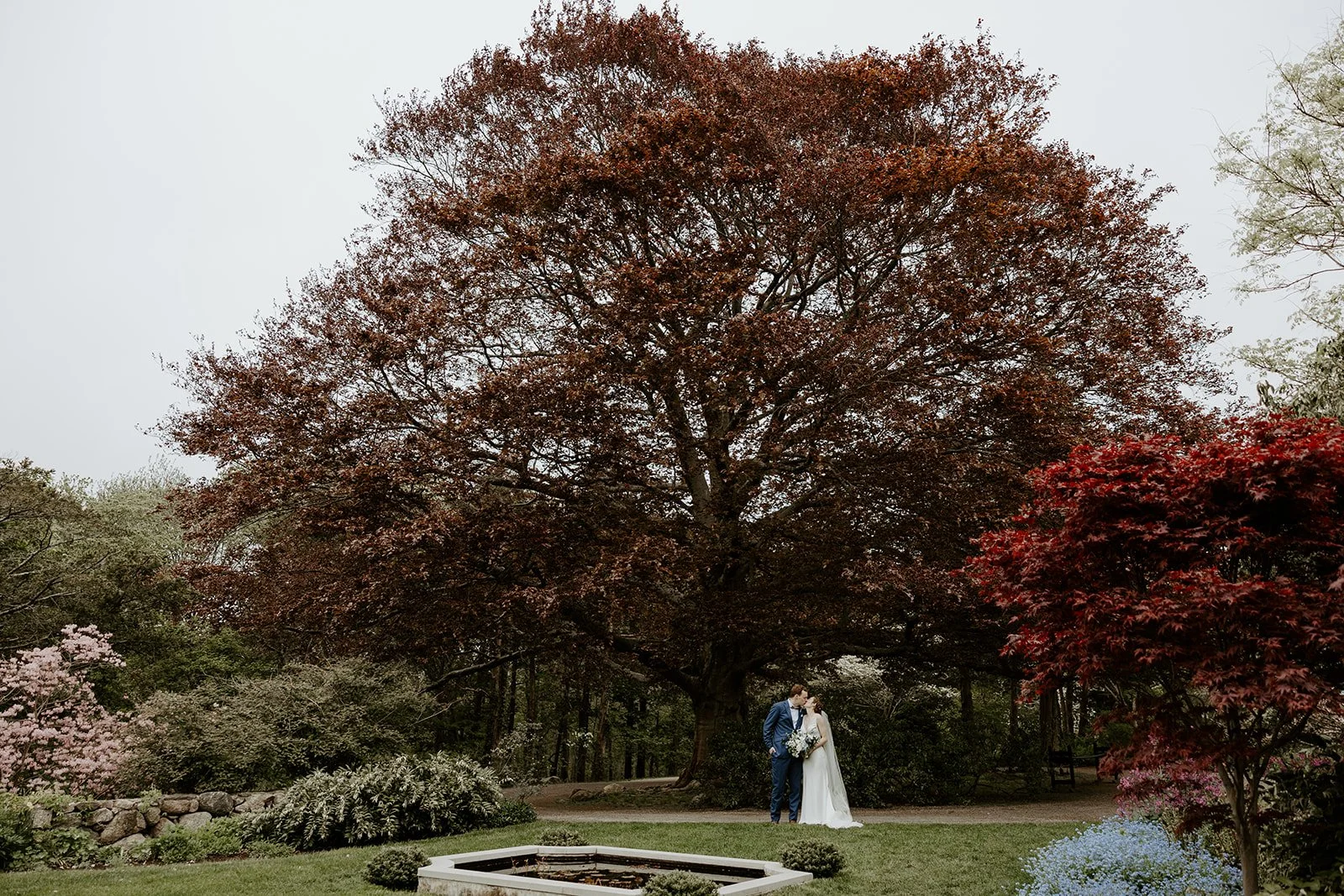 A bride and groom posing for wedding photos outside