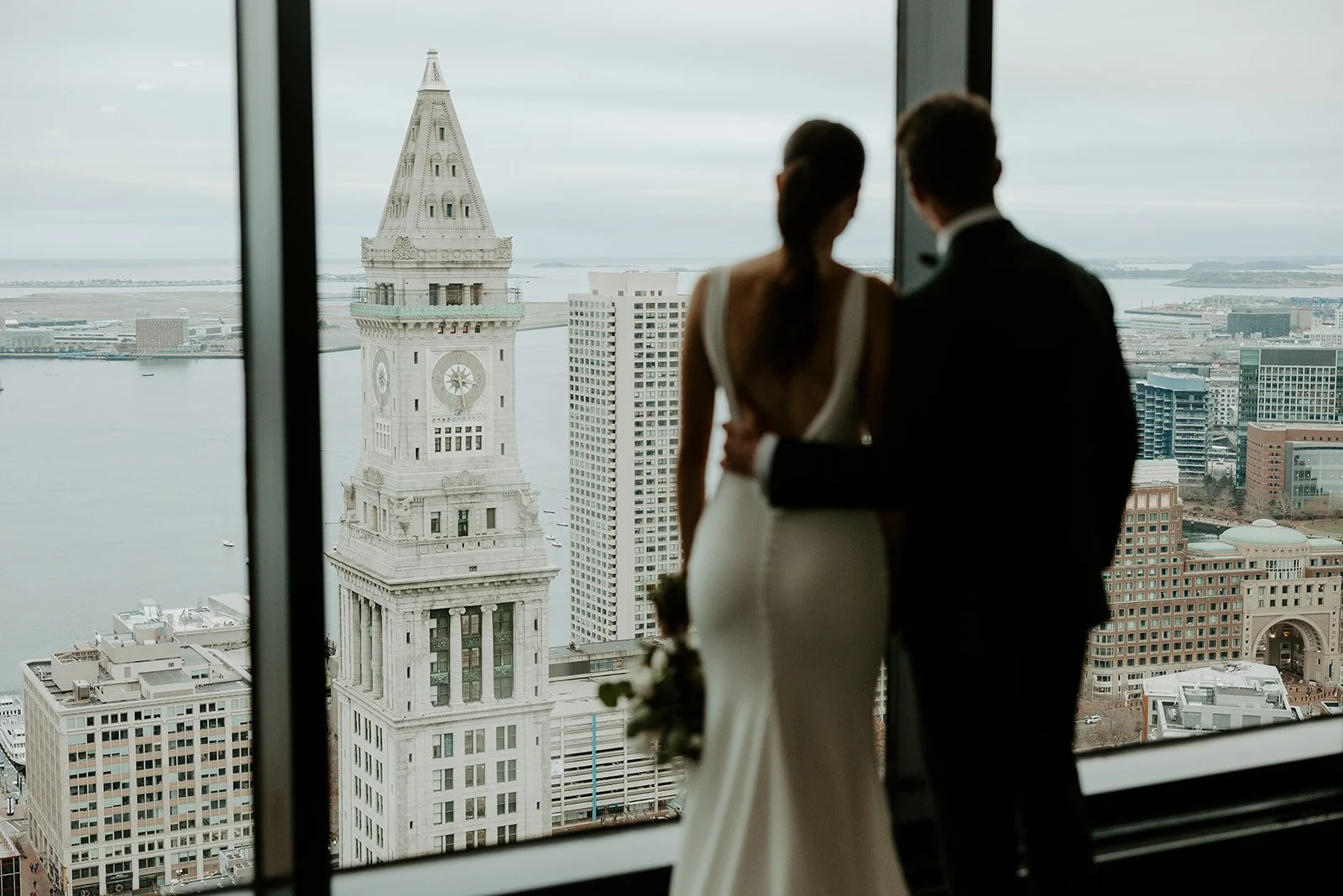 A bride and groom looking out at their city wedding setting