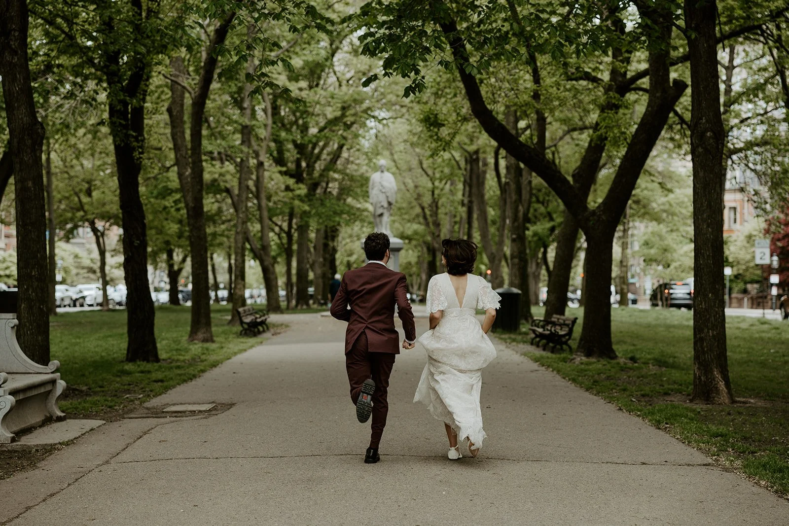 A couple running away from the camera after their Boston elopement