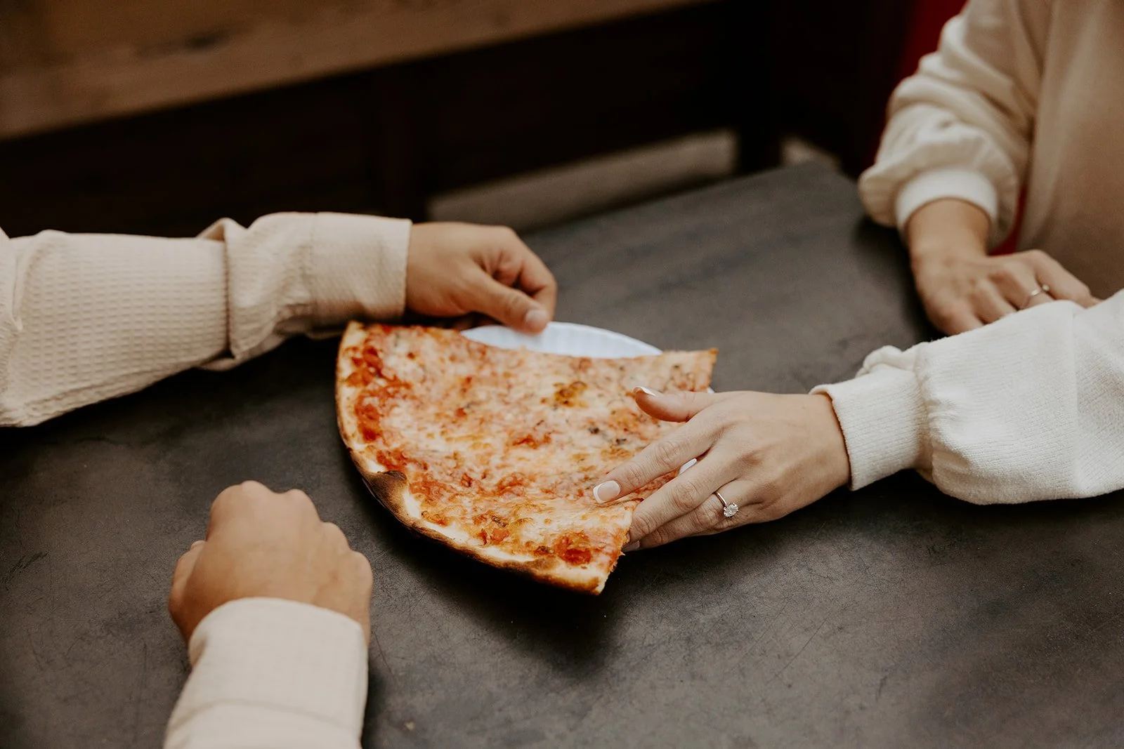 A couple sharing pizza during an engagement photoshoot