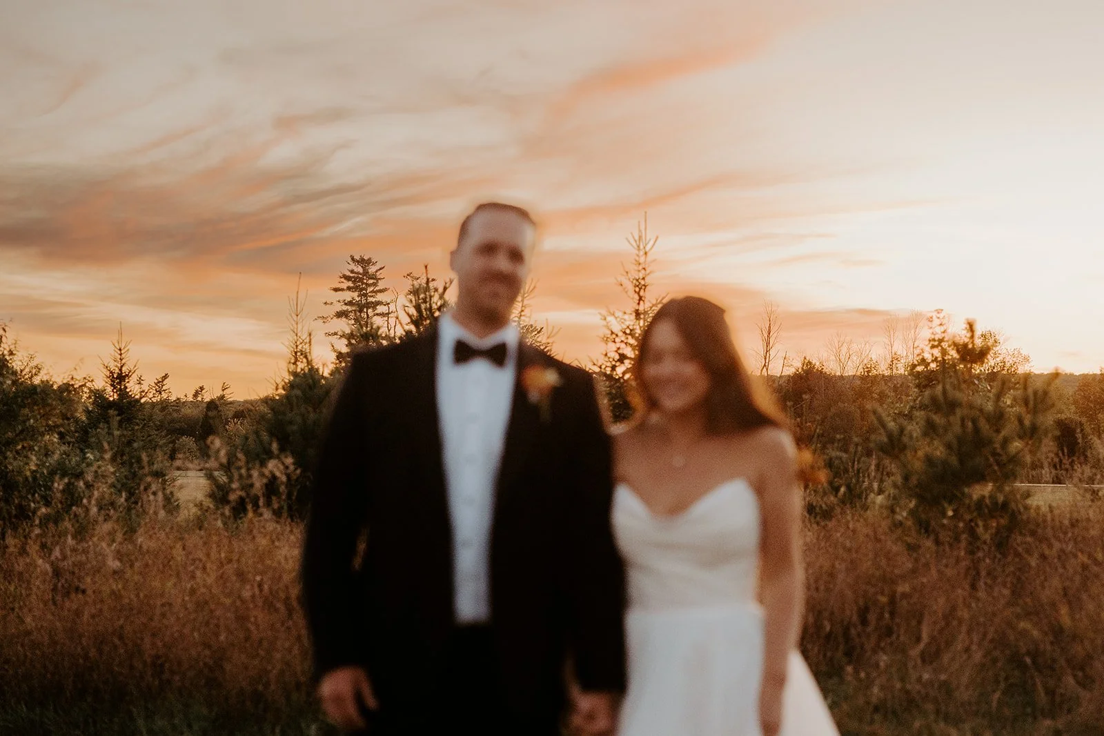 A bride and groom taking wedding sunset photos at their backyard wedding