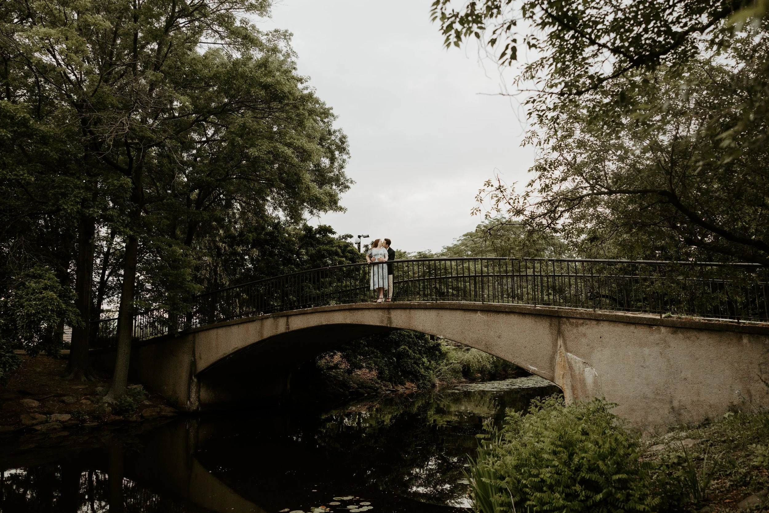 A couple posing on a bridge for engagement photos at the Esplanade
