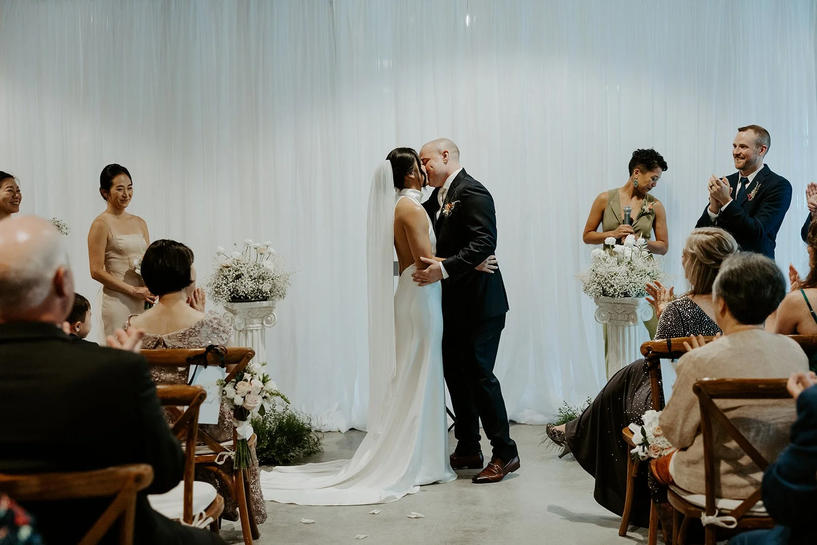 A wedding couple sharing their first kiss during their wedding ceremony at Garage B