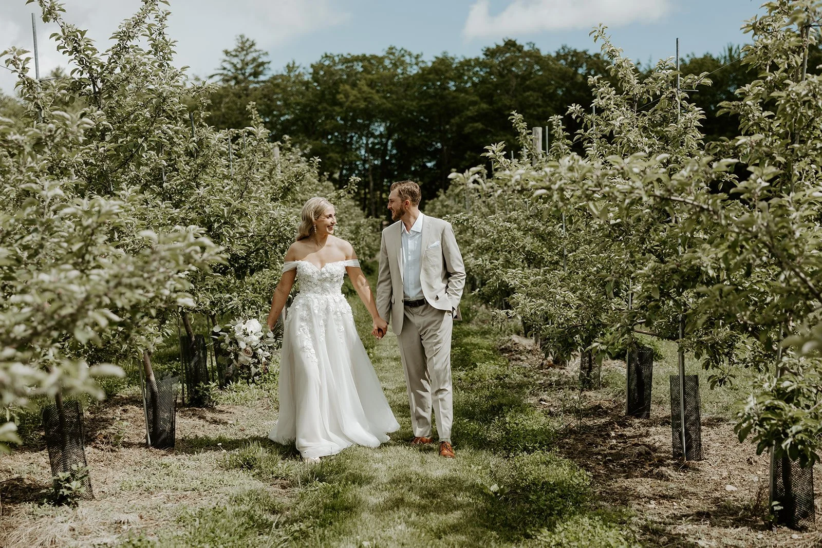 A bride and groom walking through their vineyard wedding venue