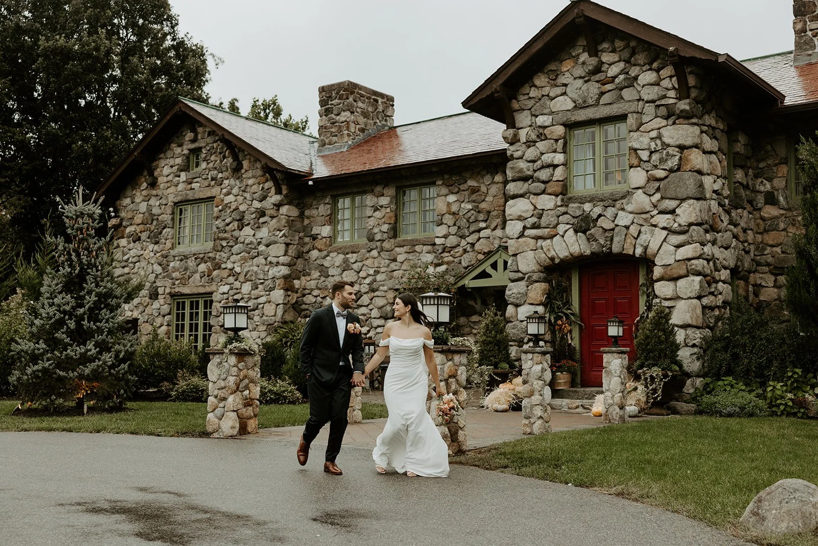 A bride and groom running in front of their estate wedding venues