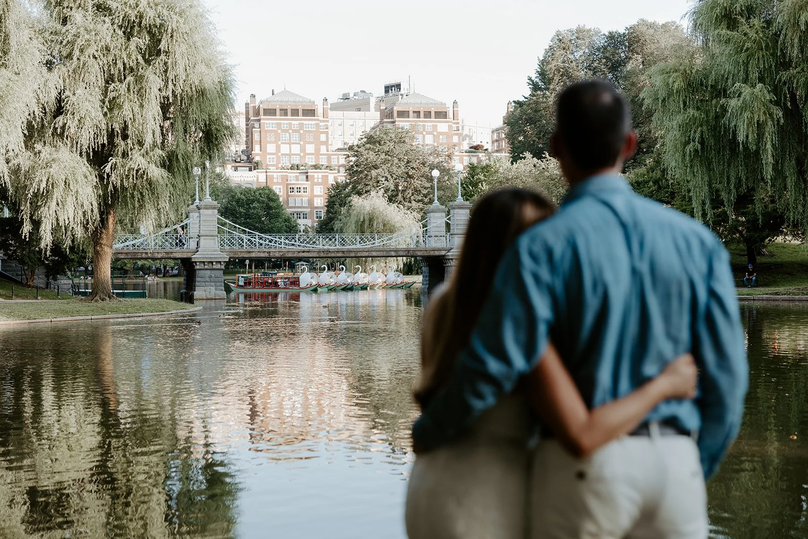 A blurry photo taken by a Boston engagement photographer of couple looking at city from Public Garden