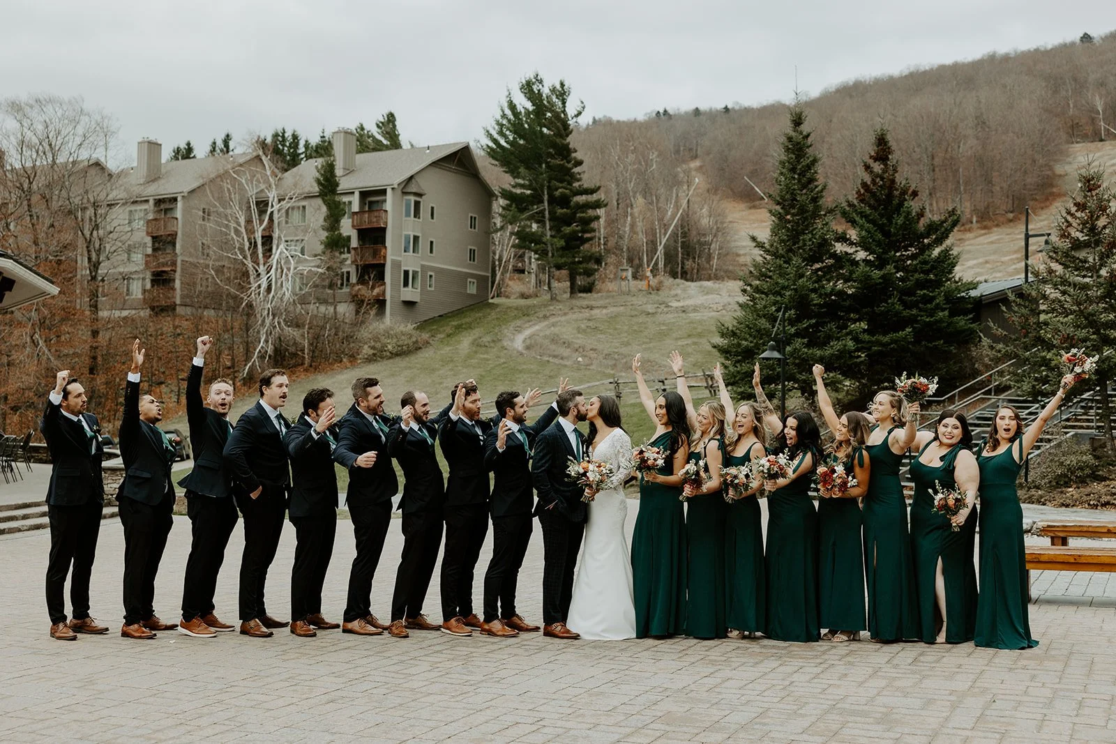 A wedding party cheering for a couple kissing