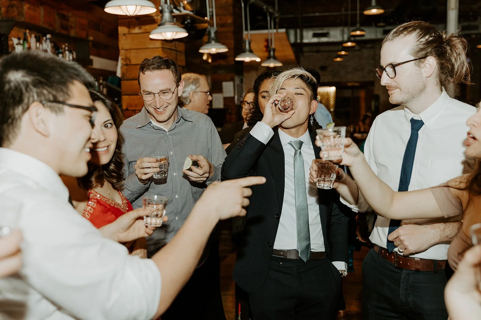 Wedding guests taking shots at a restaurant wedding reception
