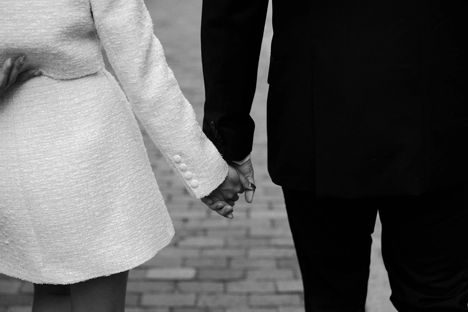 A black and white photo of a couple holding hands