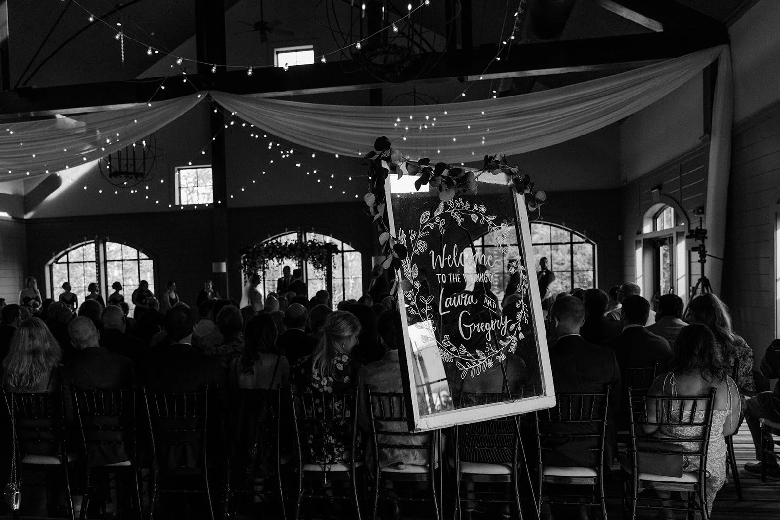 A black and white photo of an indoor wedding ceremony