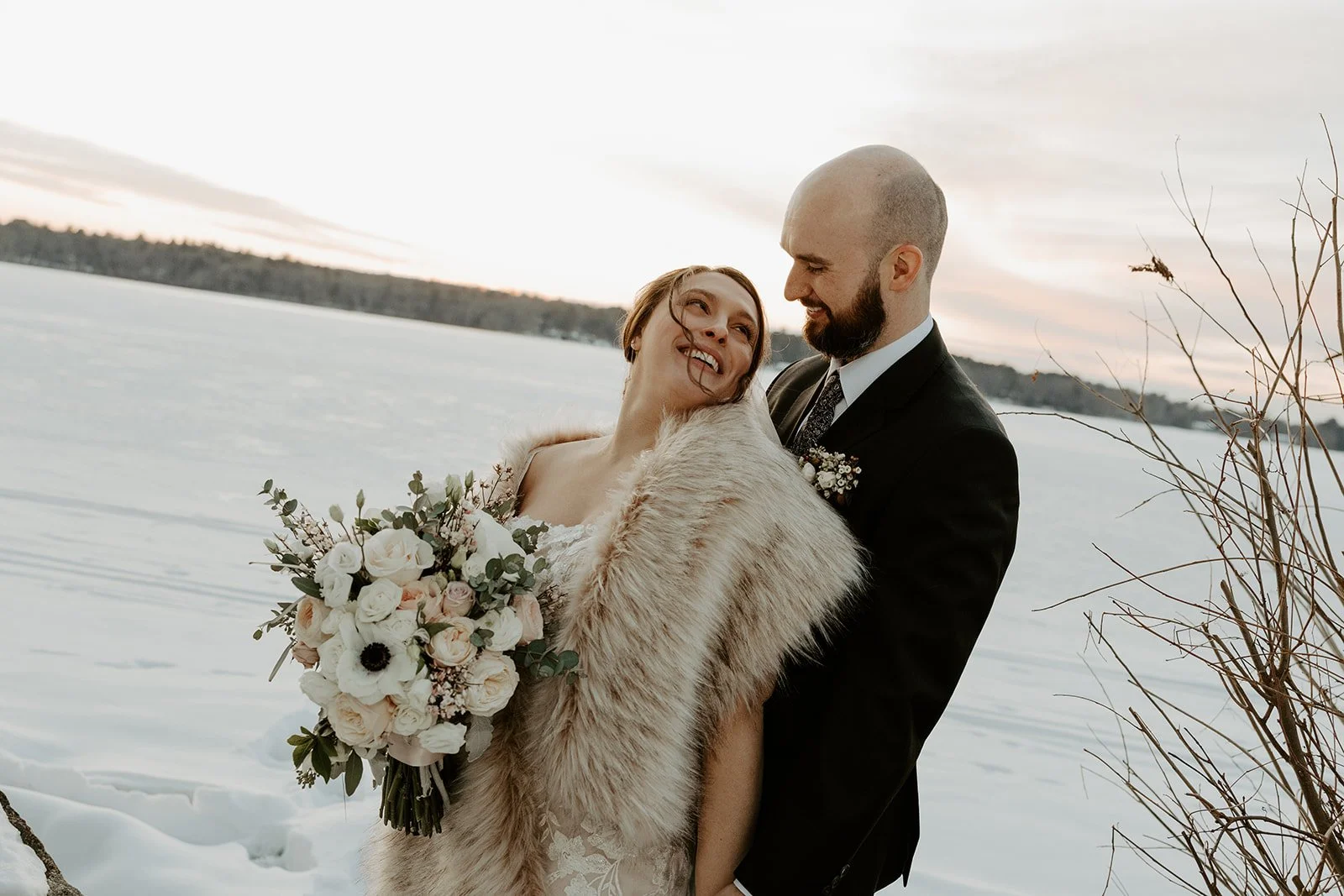 A bride and groom taking snowy wedding photos
