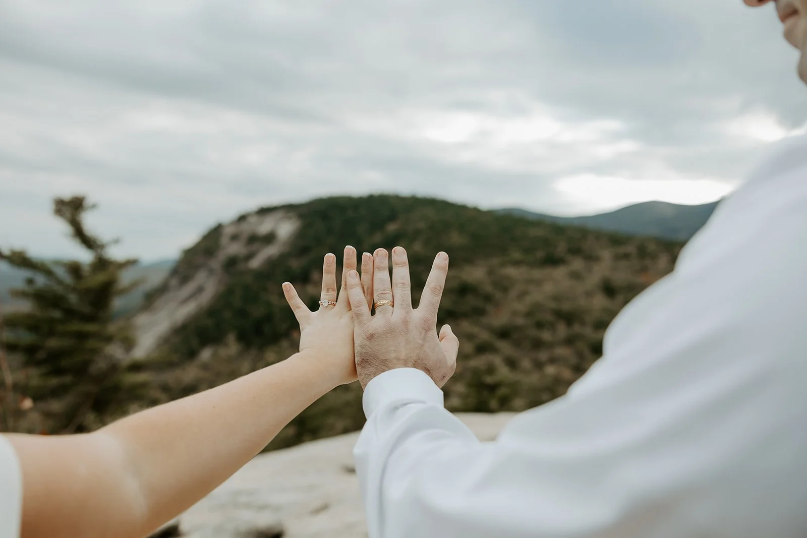 A bride and groom's rings after they learned how to plan an elopement at cathedral ledge