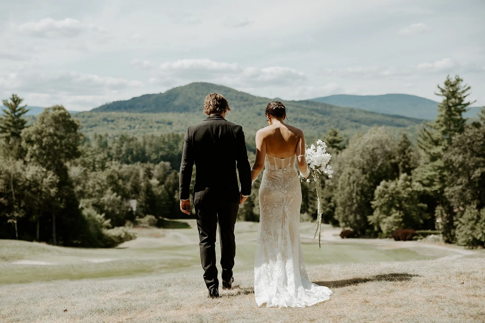 A bride and groom walking away from the camera