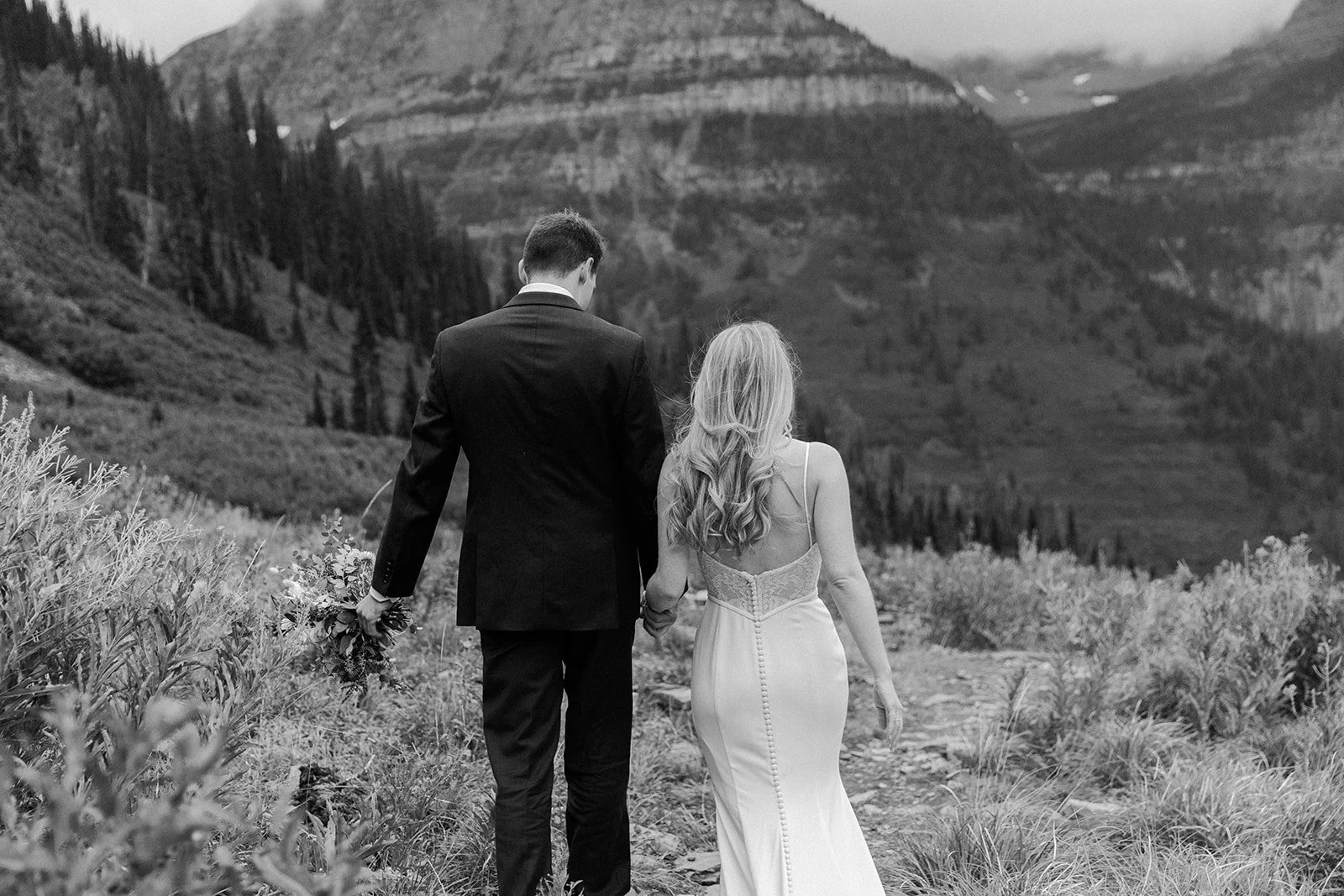 A couple walking through Glacier national park, their elopement location