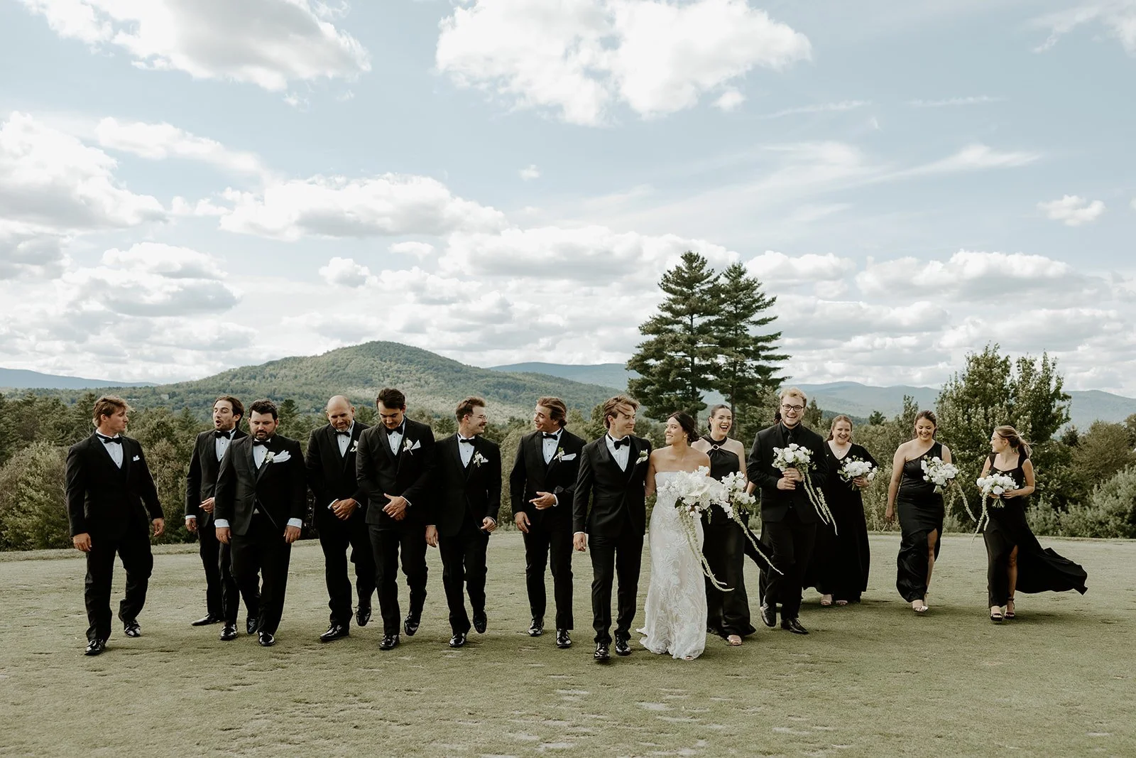 A wedding party taking photos in front of some mountains