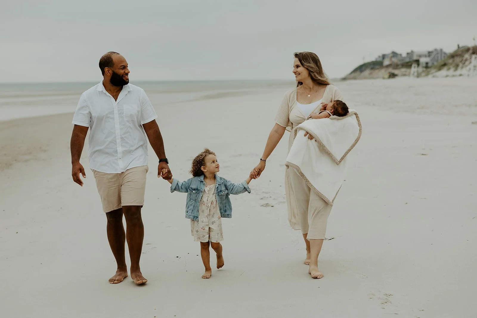 A family holding hands and walking during a beach family photoshoot