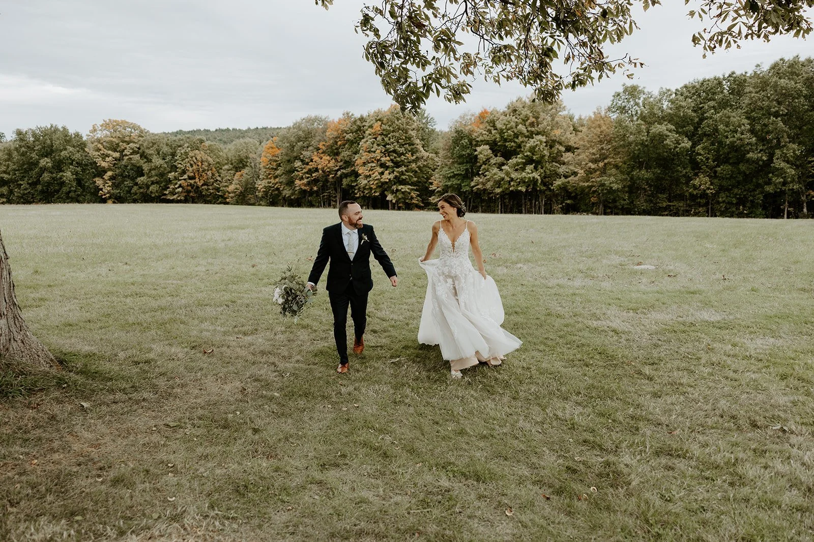 A bride and groom walking through the orchards at valley view farm