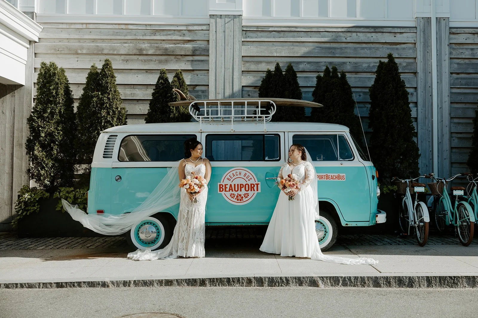 Two brides posing in front of an old VW bus