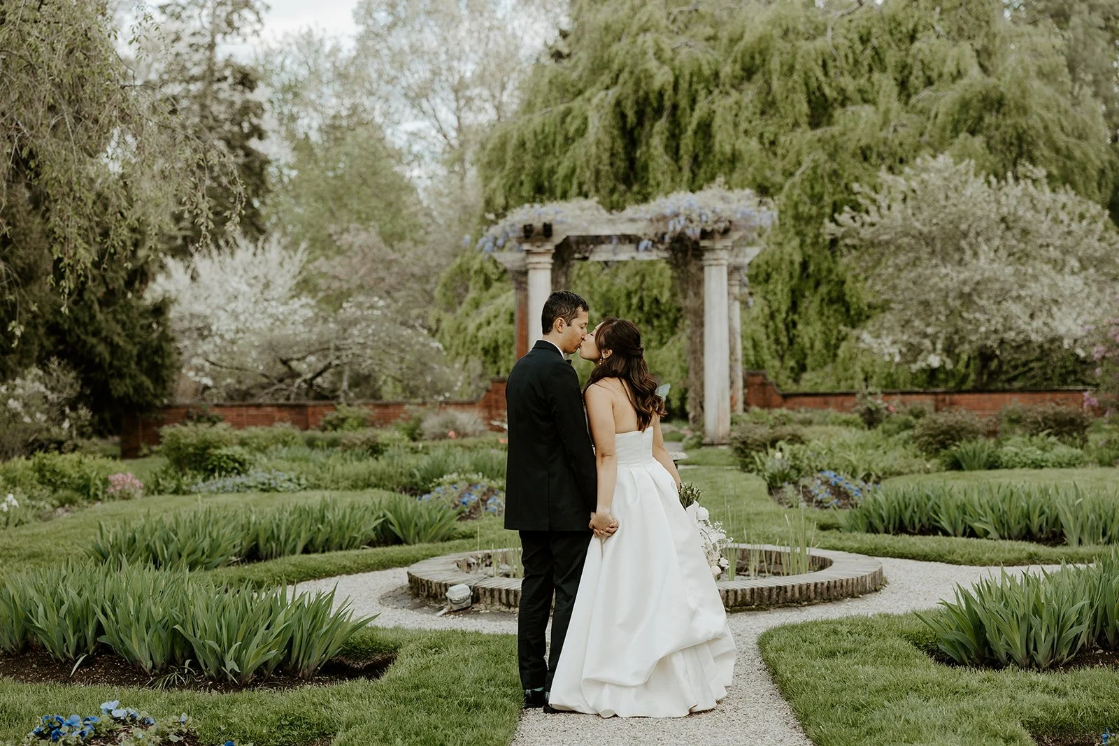 A bride and groom kissing in the gardens at their estate wedding venue