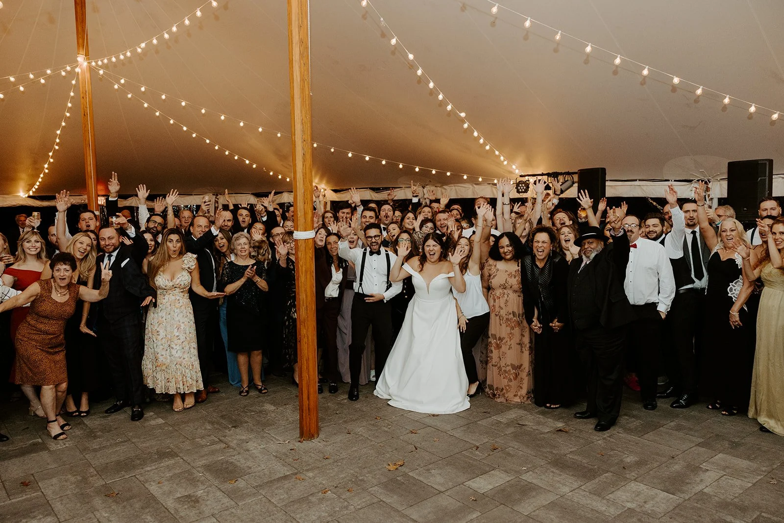 A couple posing for a photo with their wedding guests