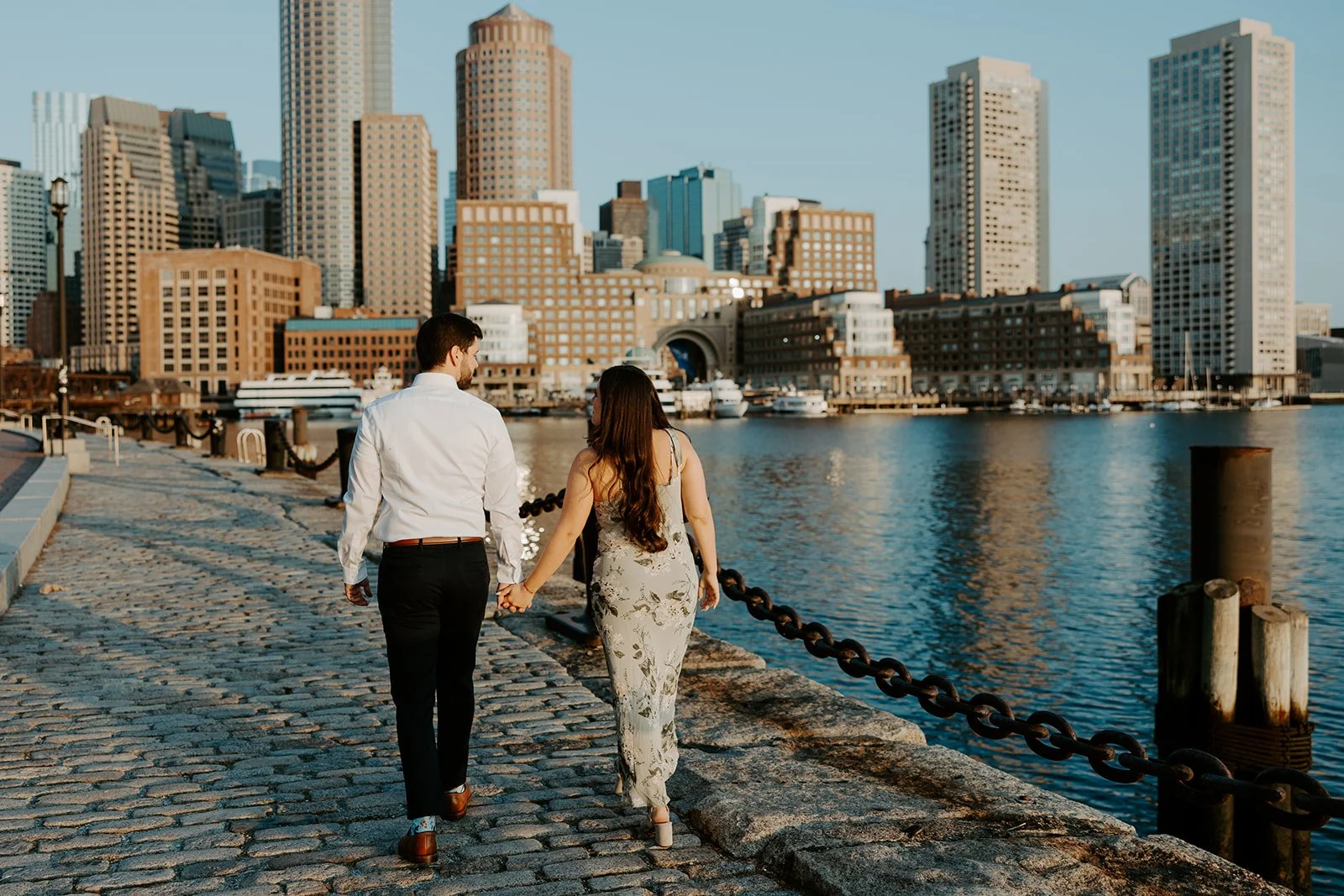 A couple walking towards the city at fan pier park