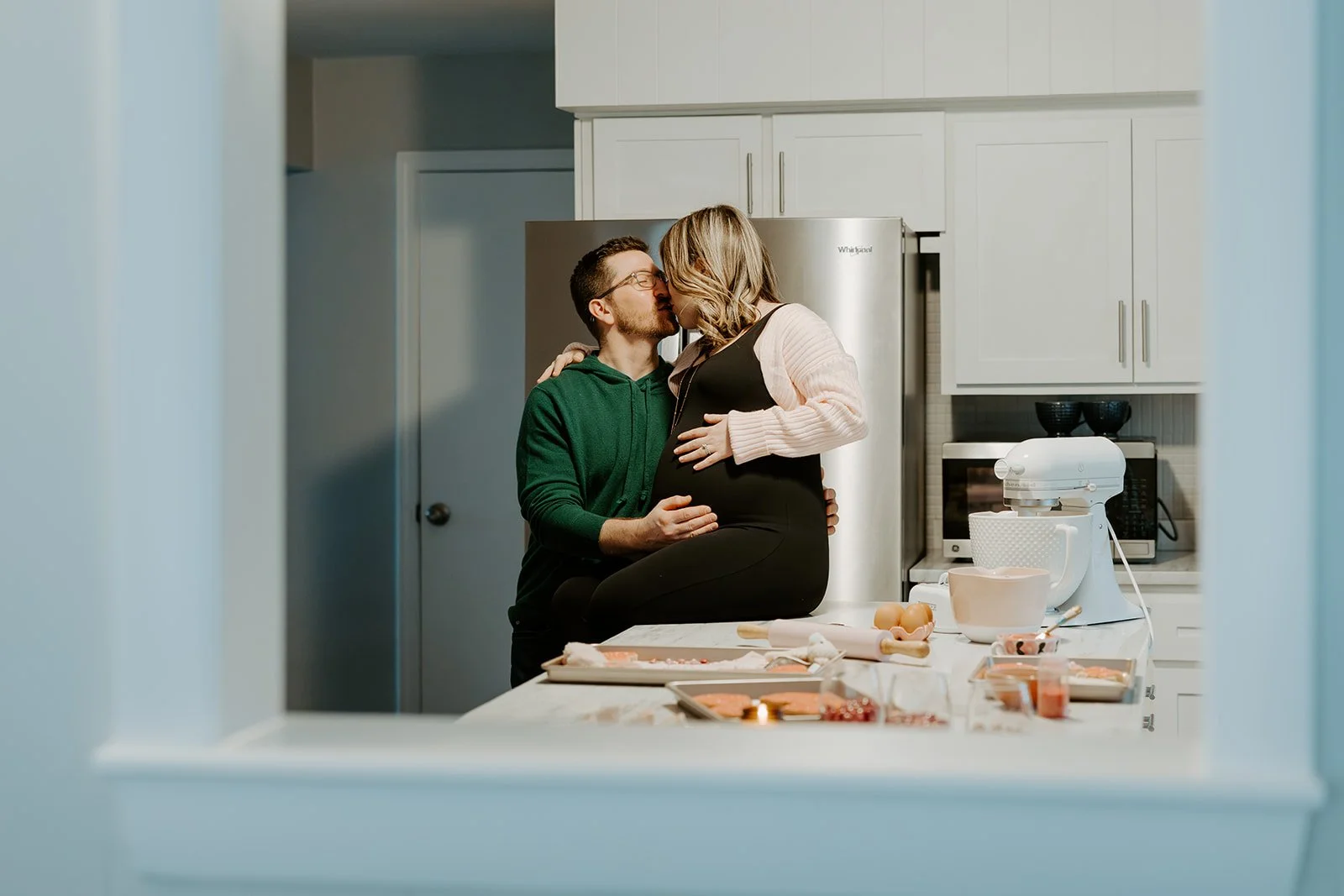 A couple kissing during their maternity photoshoot