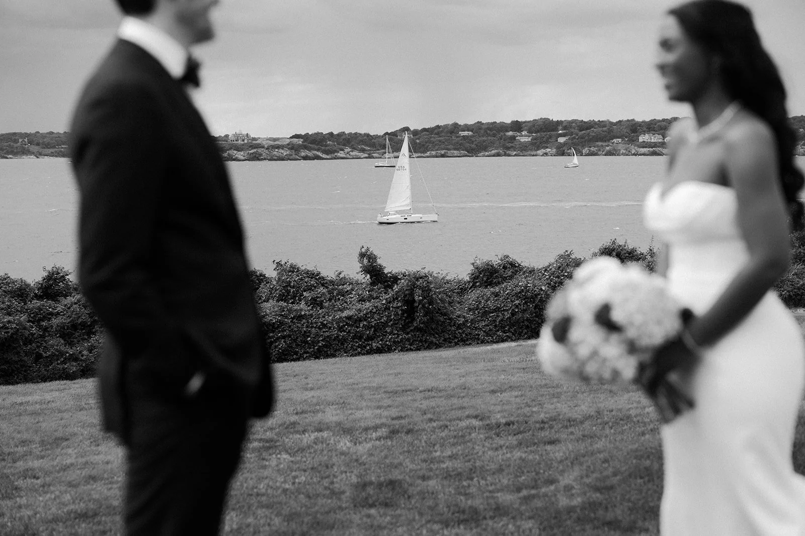 A bride and groom posing in front of water for their summer wedding