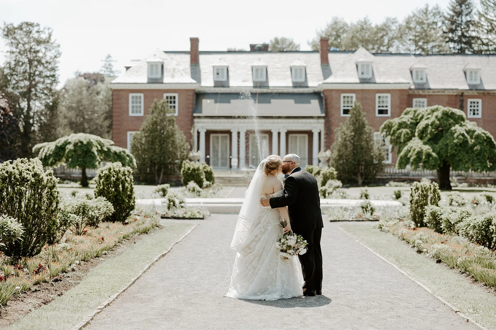 A bride and groom kissing at an estate wedding venue