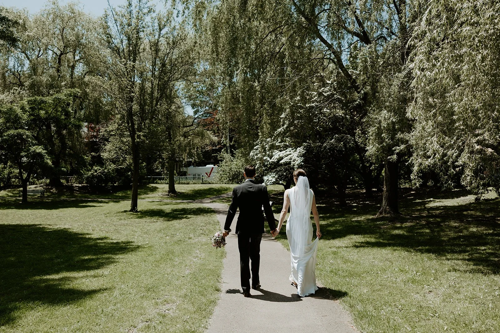 A couple walking through a park after their Boston Public Library elopement