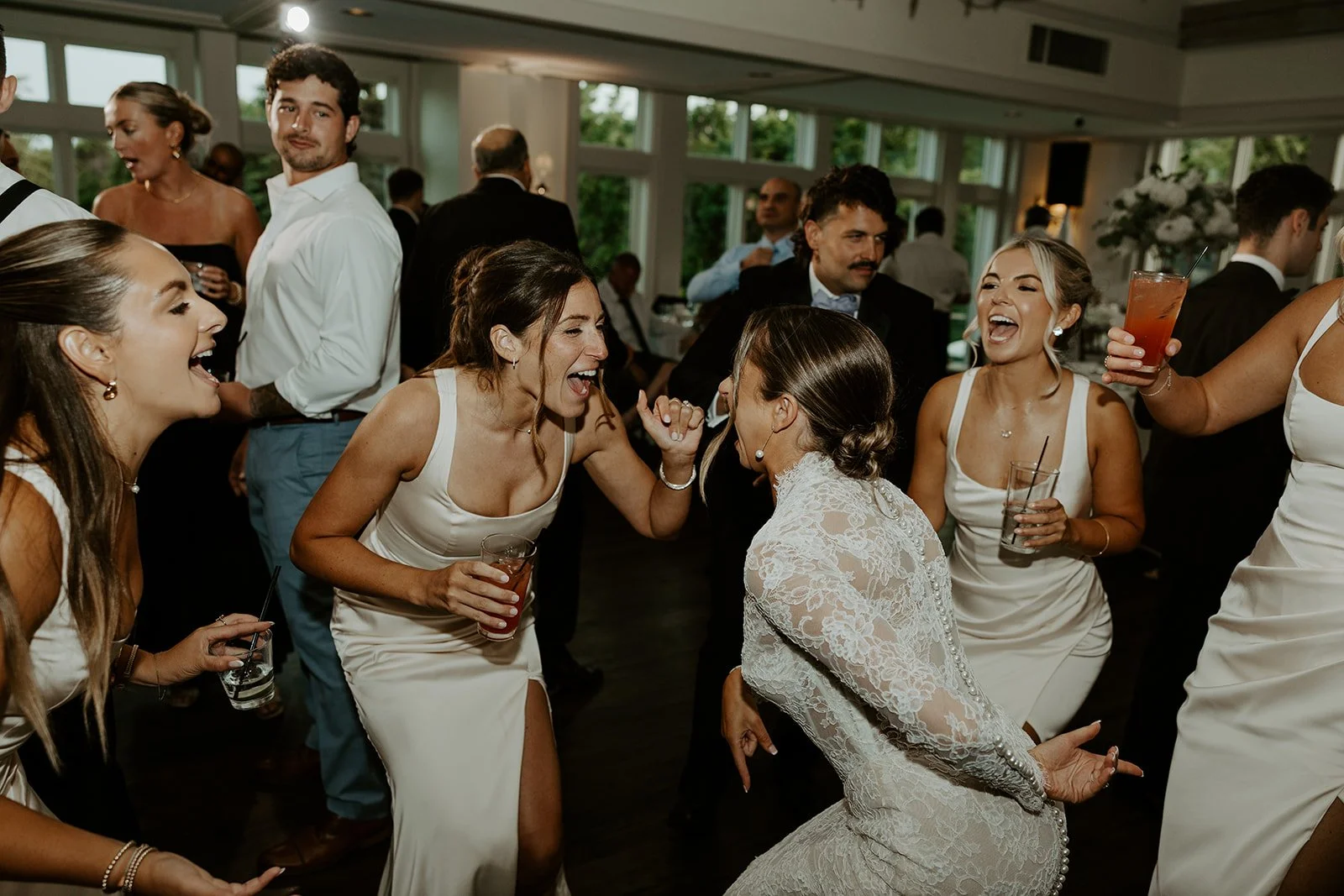A candid photo of a bride dancing with her friends on the dance floor