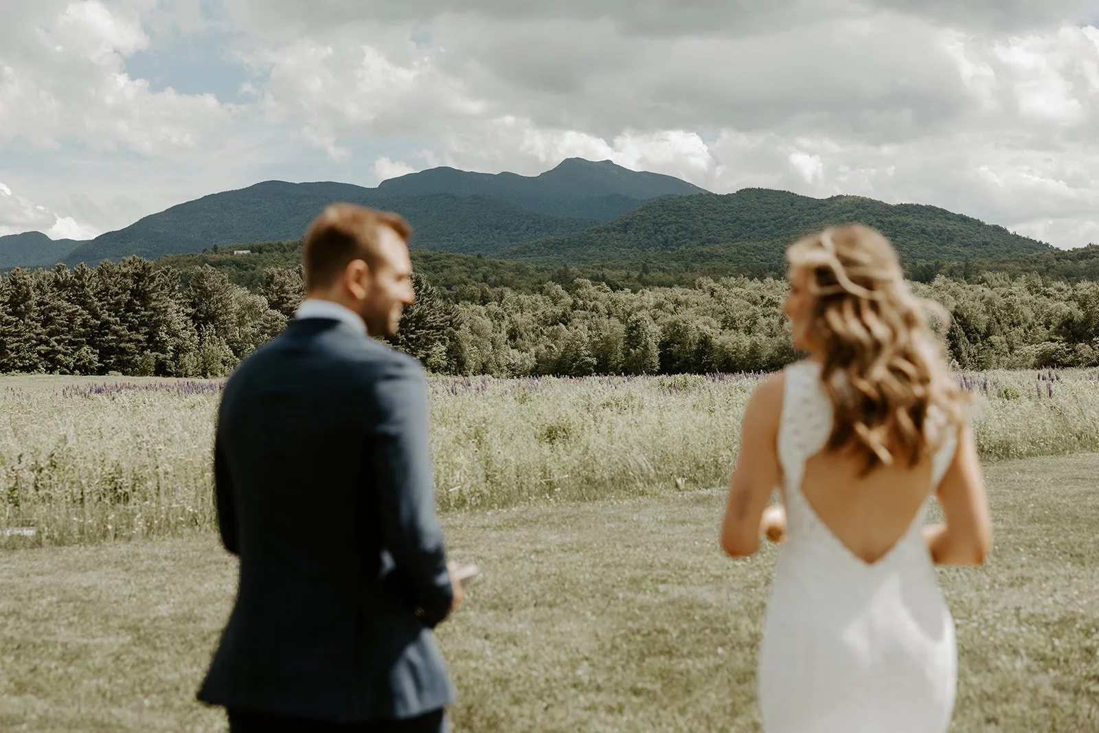 A couple looking at each other in front of a mountain at their Vermont wedding venue