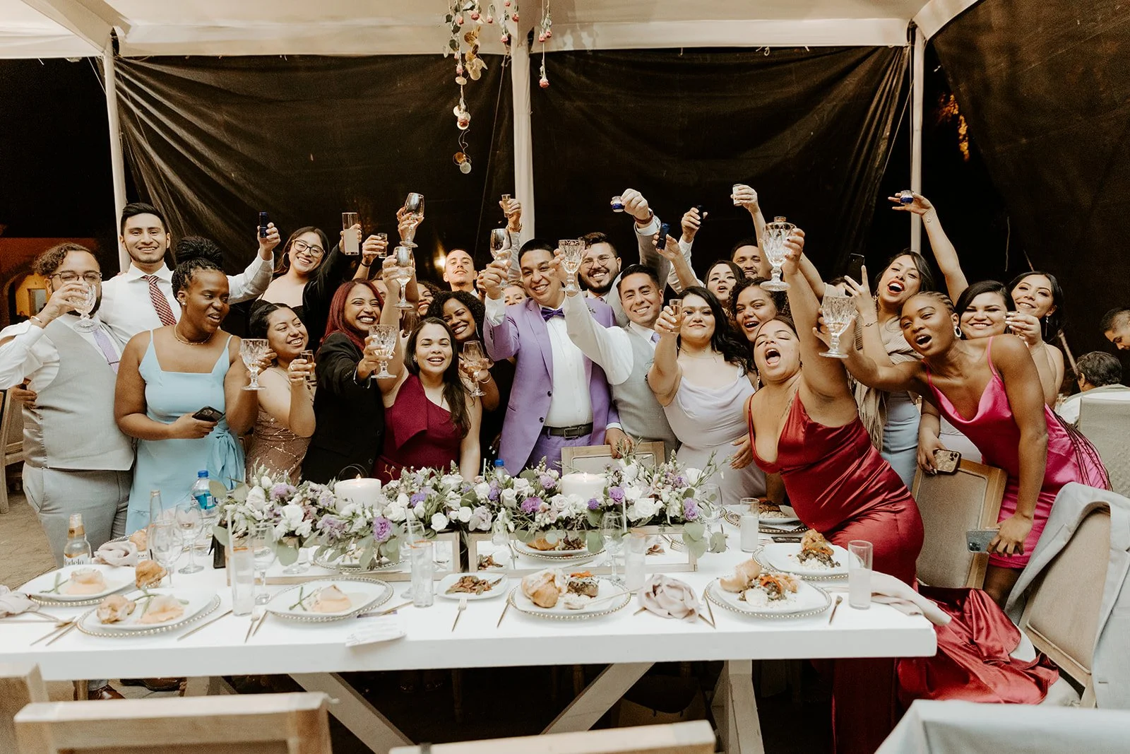 A wedding reception cheering with wedding guests