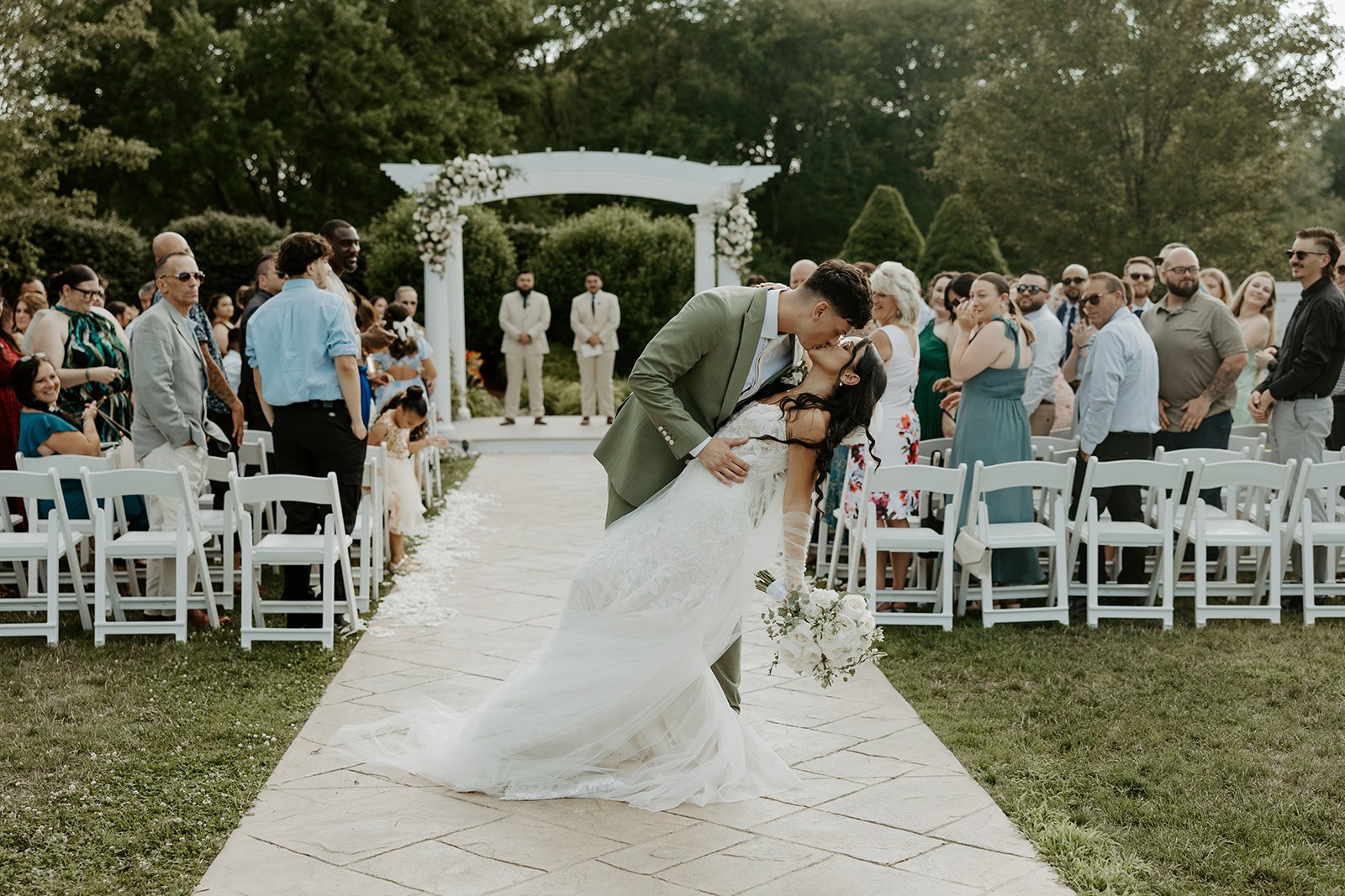 A bride and groom kissing after their wedding ceremony