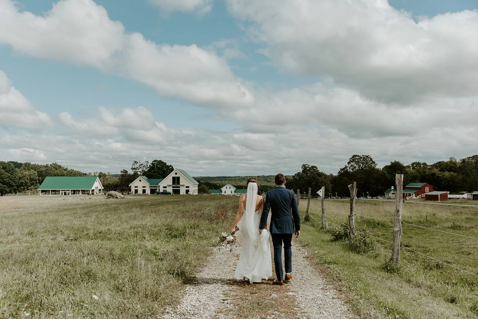 A bride and groom walking towards their wedding venue, Valley View Farm