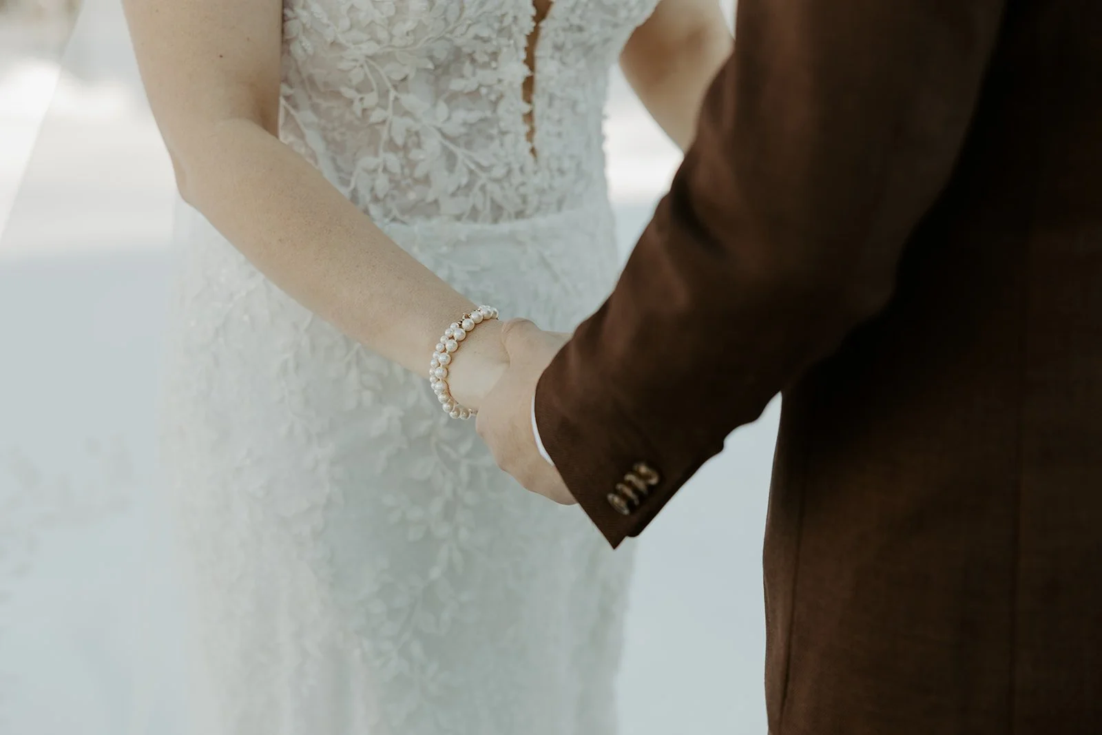 A bride and groom holding hands during off season wedding photos
