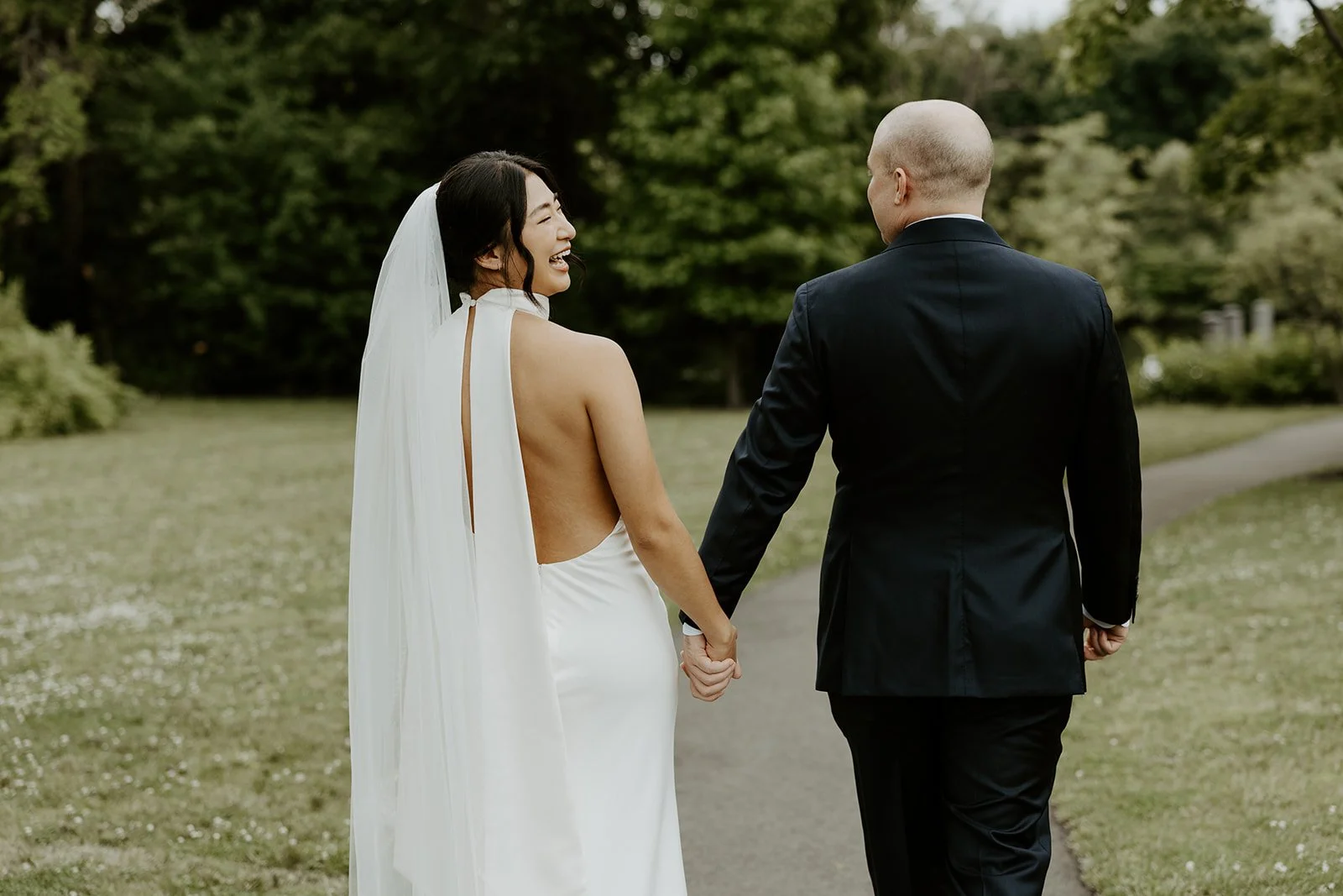 A bride laughing while walking with. her groom