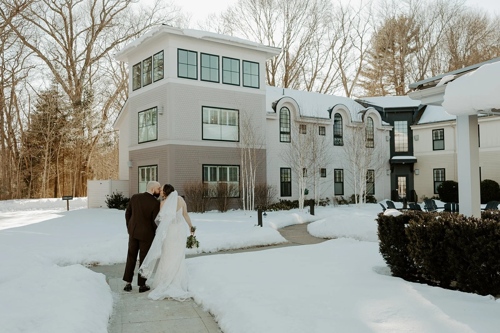 A bride and groom walking in front of their Boston wedding venue during wedding off season
