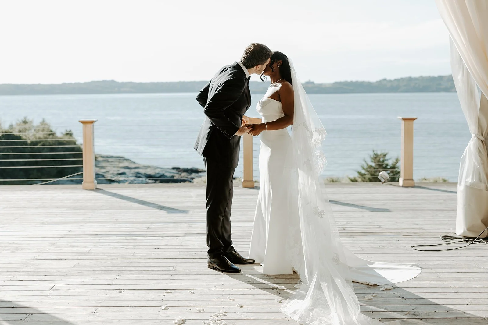A bride and groom kissing during their summer wedding ceremony