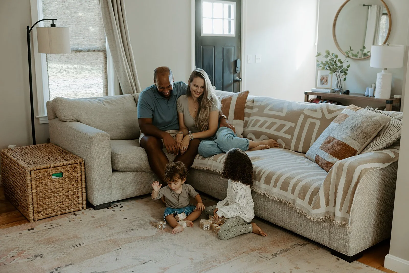 family photos at home, with parents on a couch and children on the floor