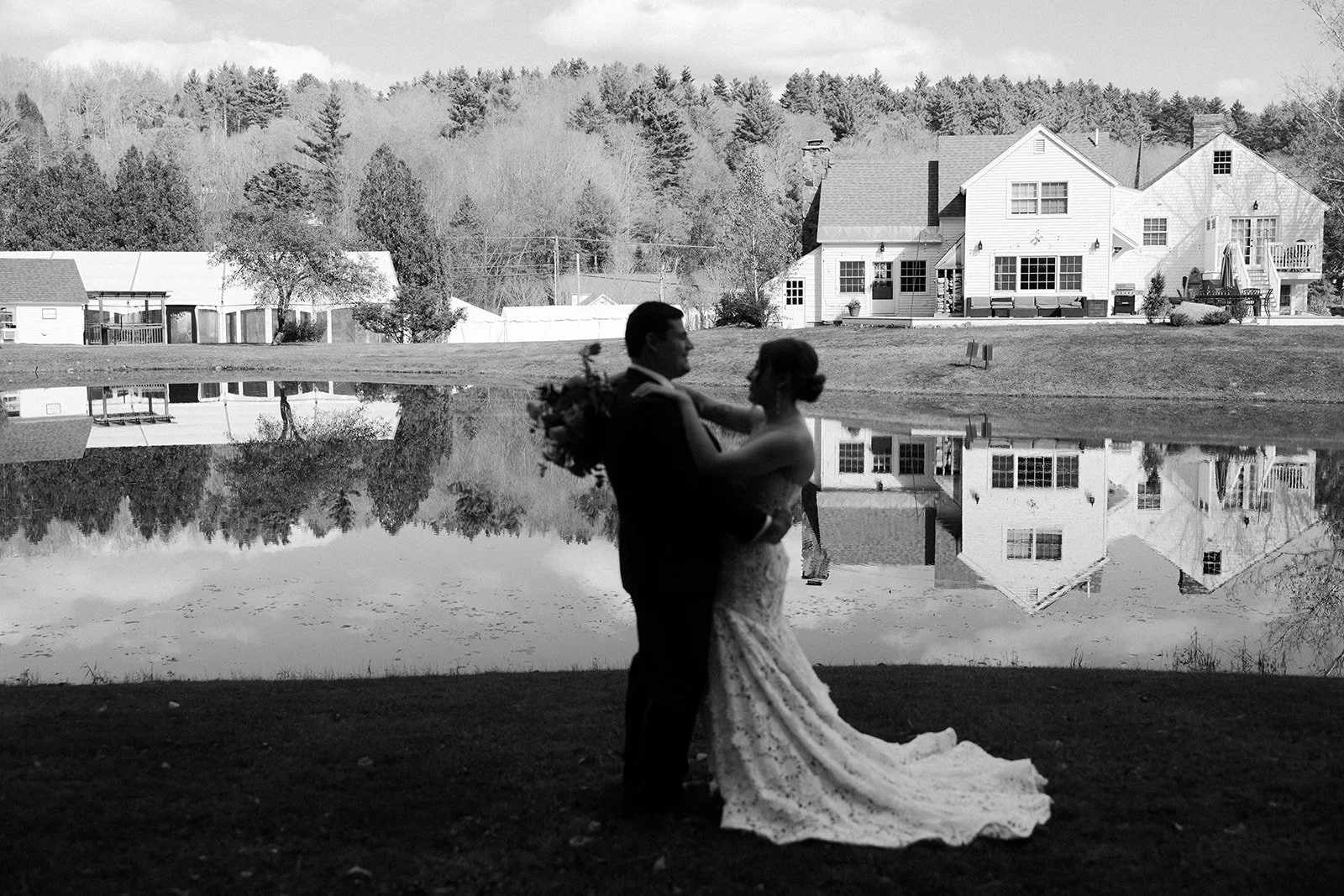 A bride and groom posing for wedding photos in front of their Vermont wedding venue