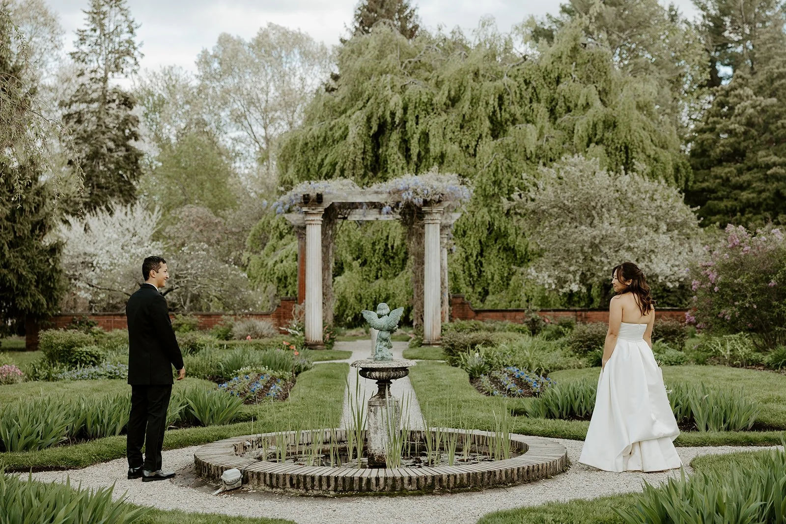 a couple on either side of a fountain in the Glen Magna Farms courtyard
