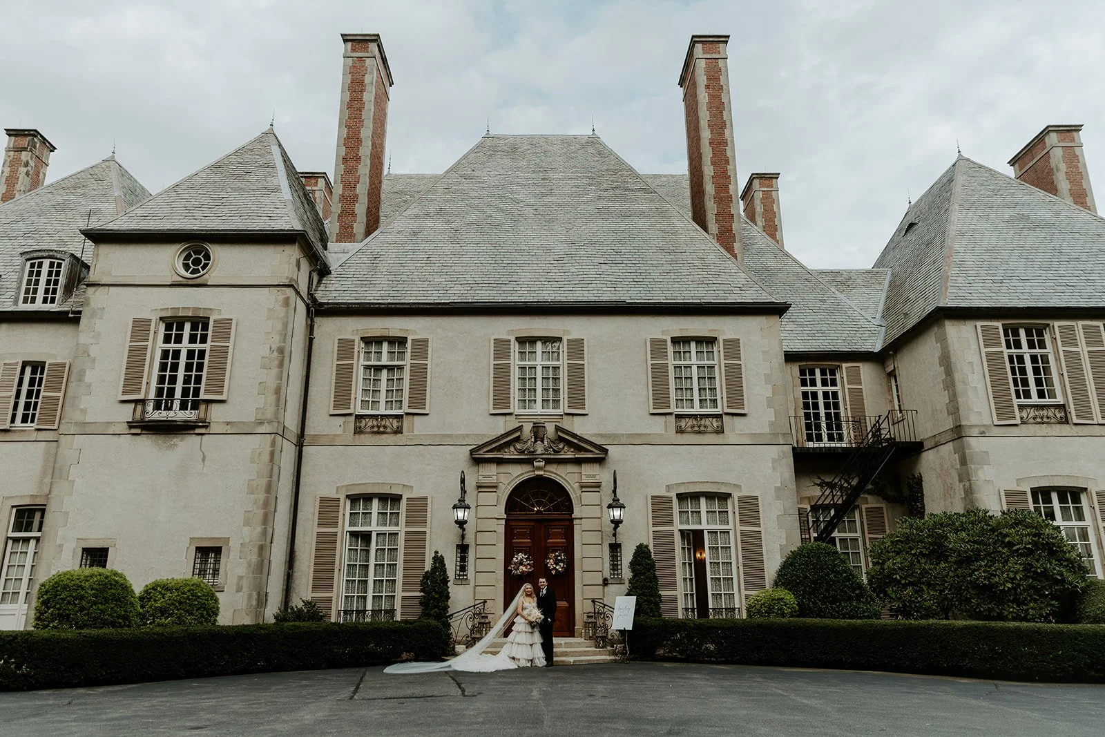 A bride and groom standing outside of their Rhode Island wedding venue Glen Manor house