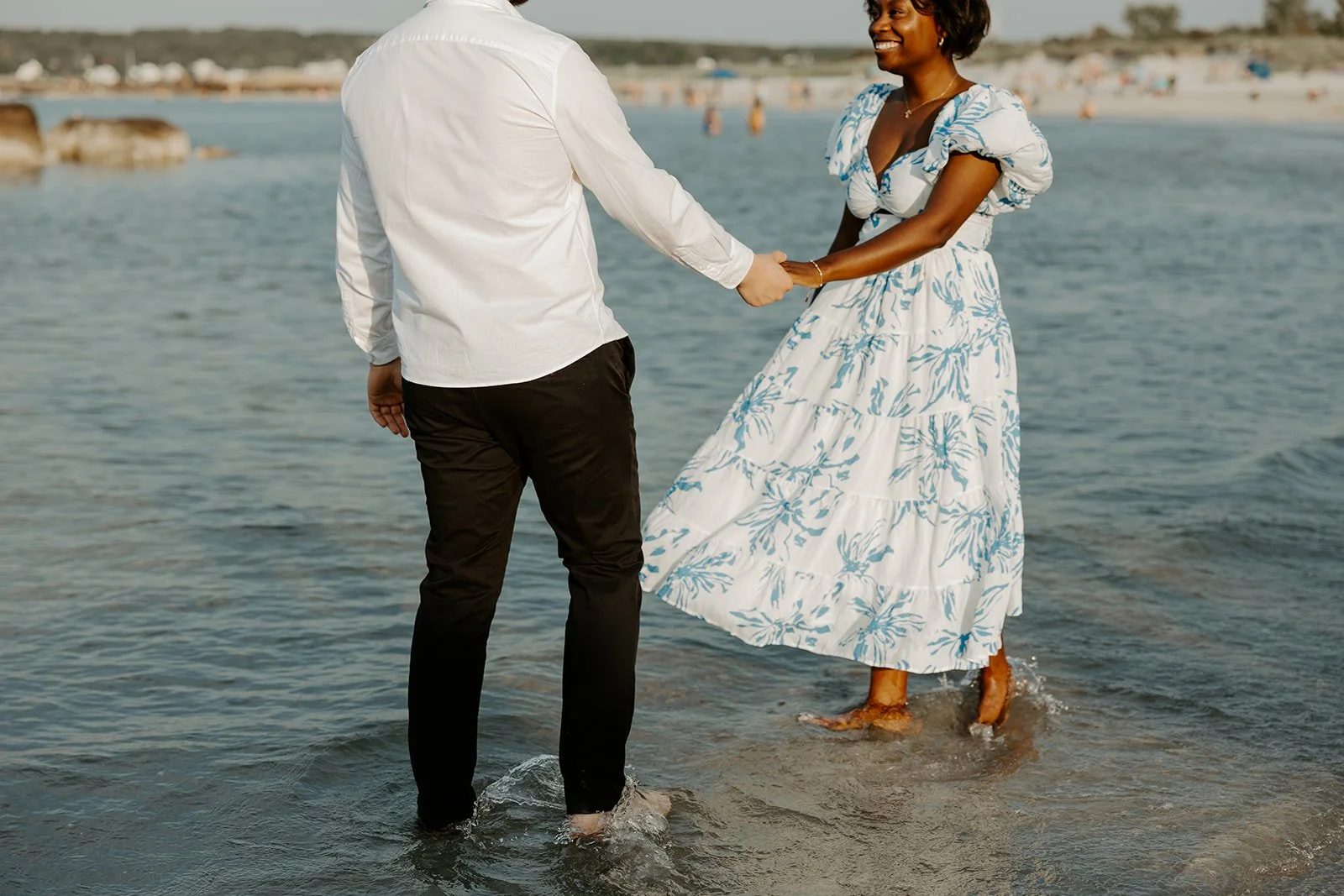 A couple taking beach engagement photos at Wingaersheek beach
