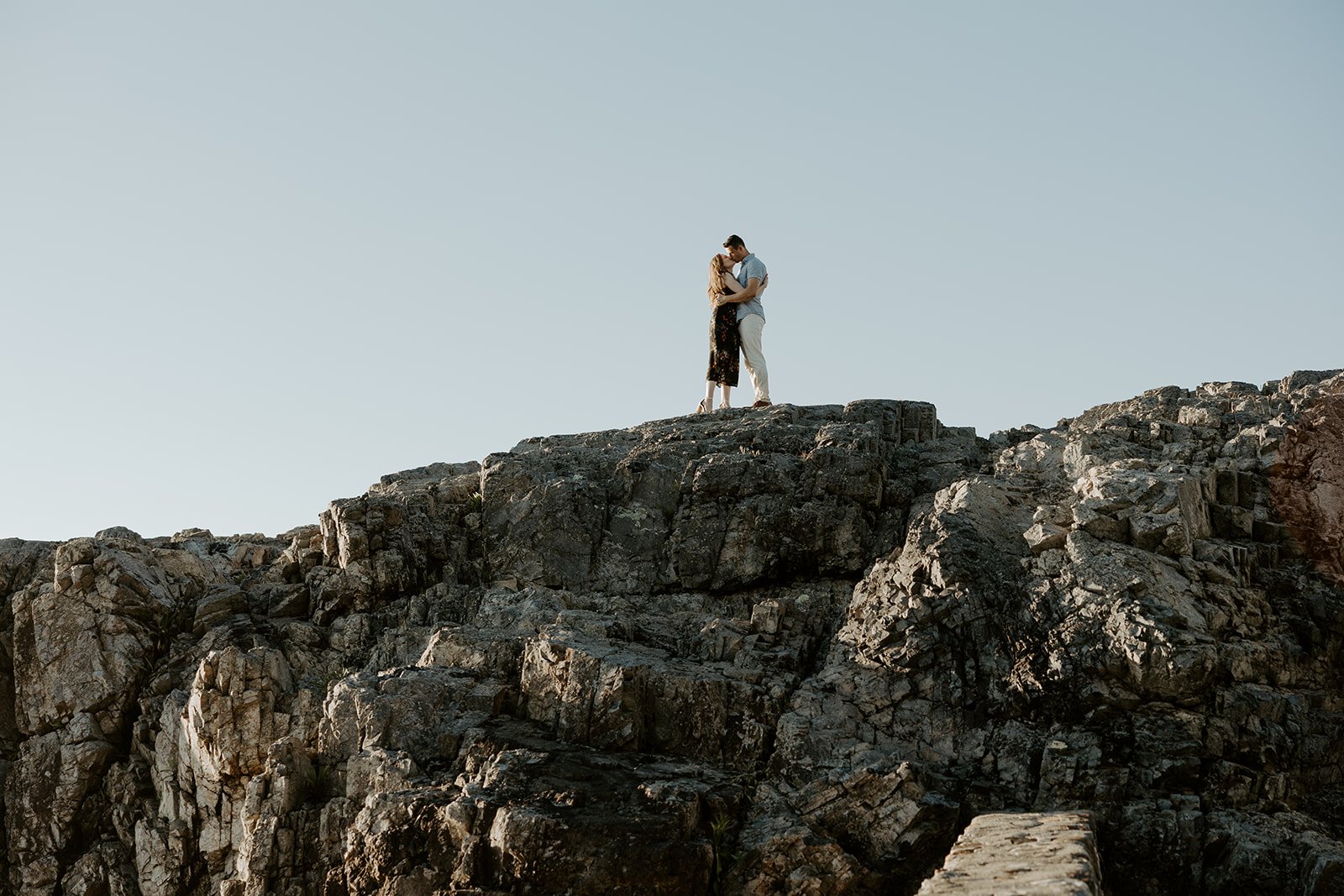 A couple kissing on top of a rock formation at Castle Rock engagement photos