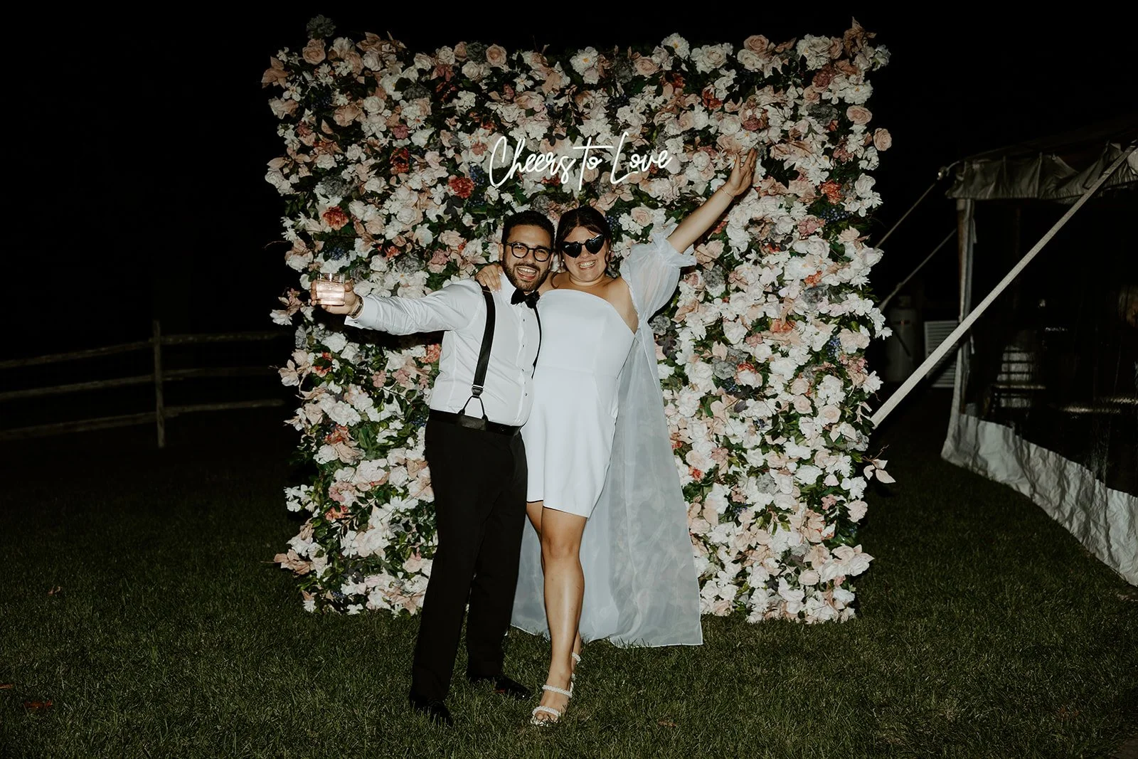 A bride and groom cheering at their wedding reception