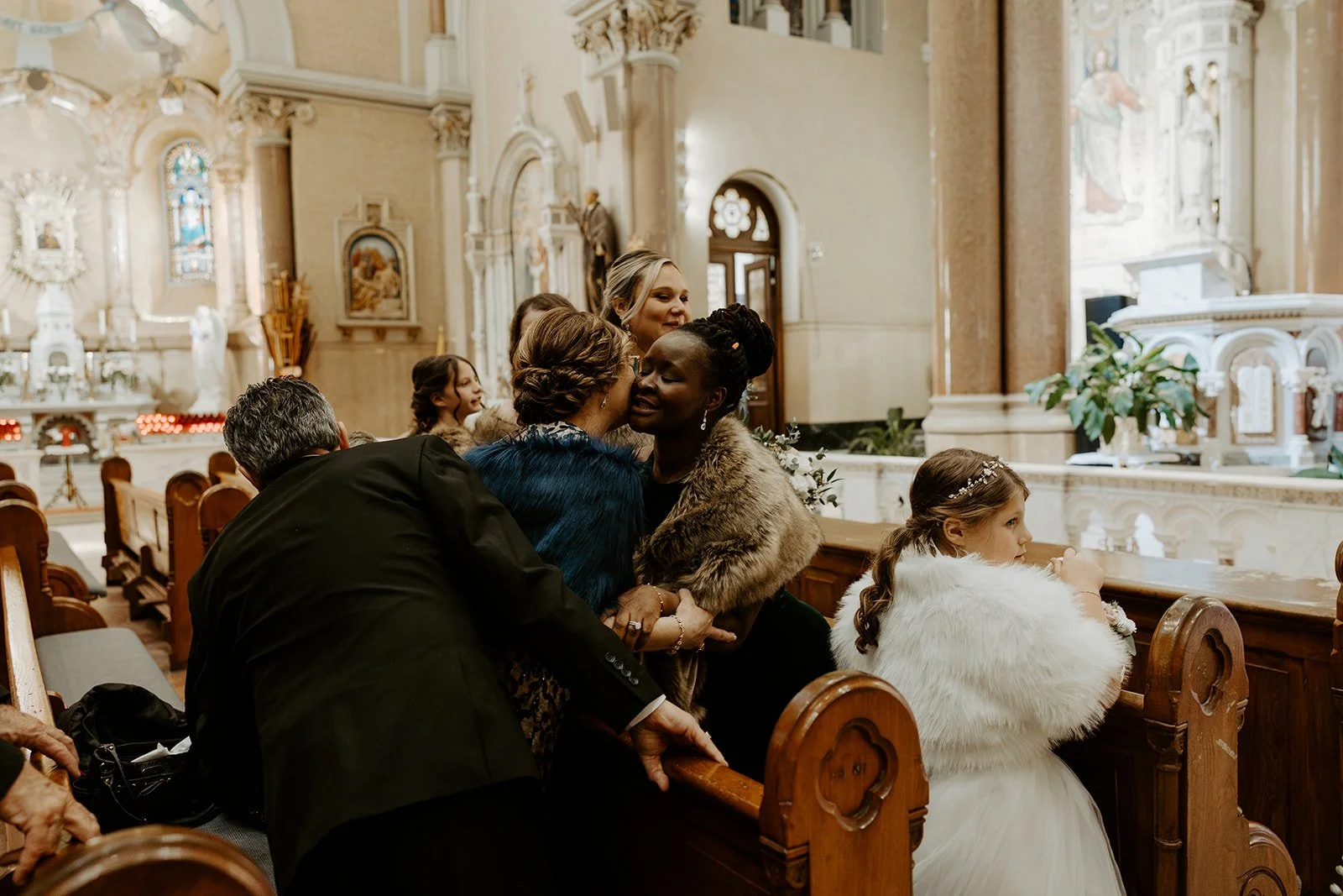 Wedding guests hugging at an indoor wedding ceremony during off season