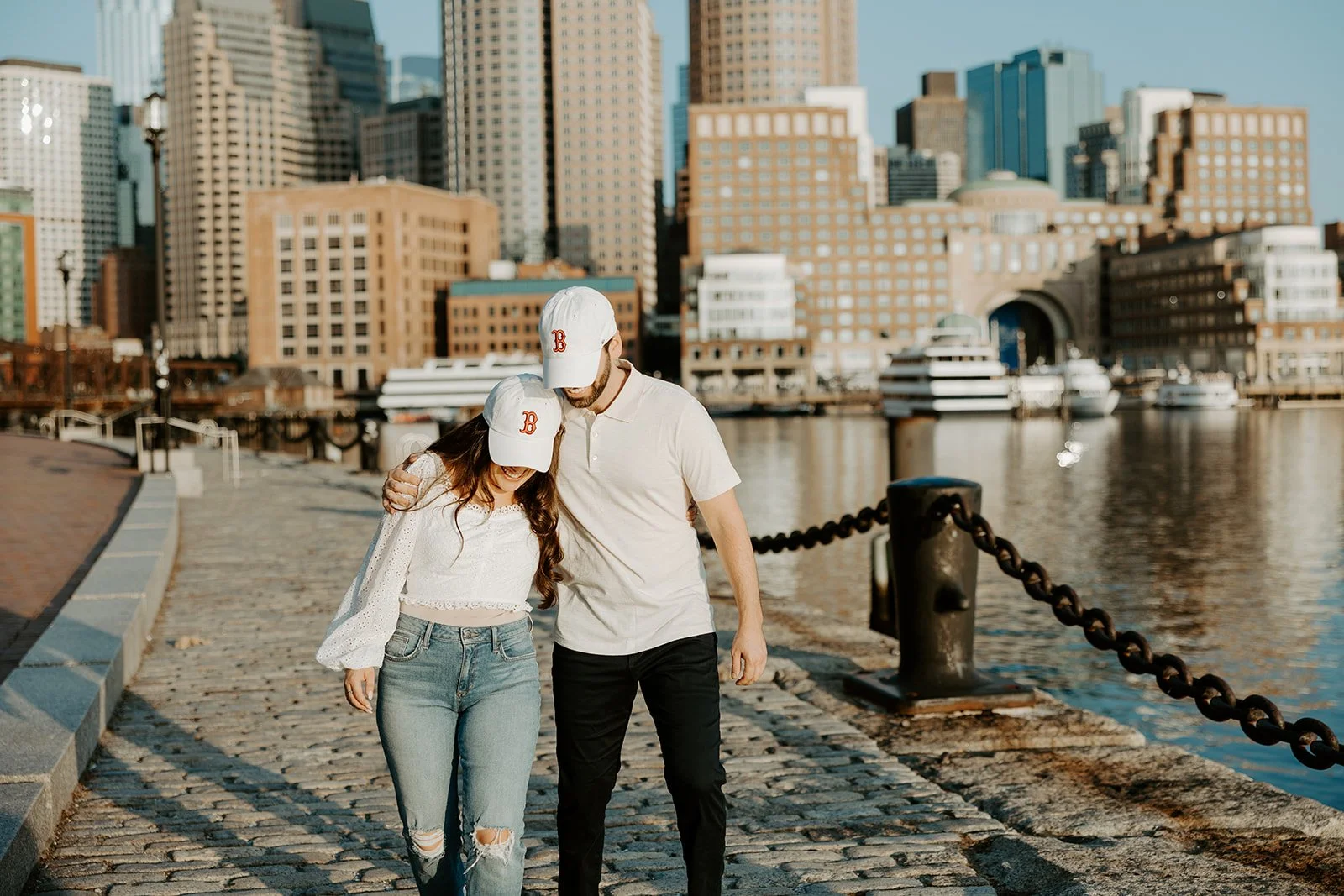 A couple wearing Boston Red Sox hats in their Boston engagement photos