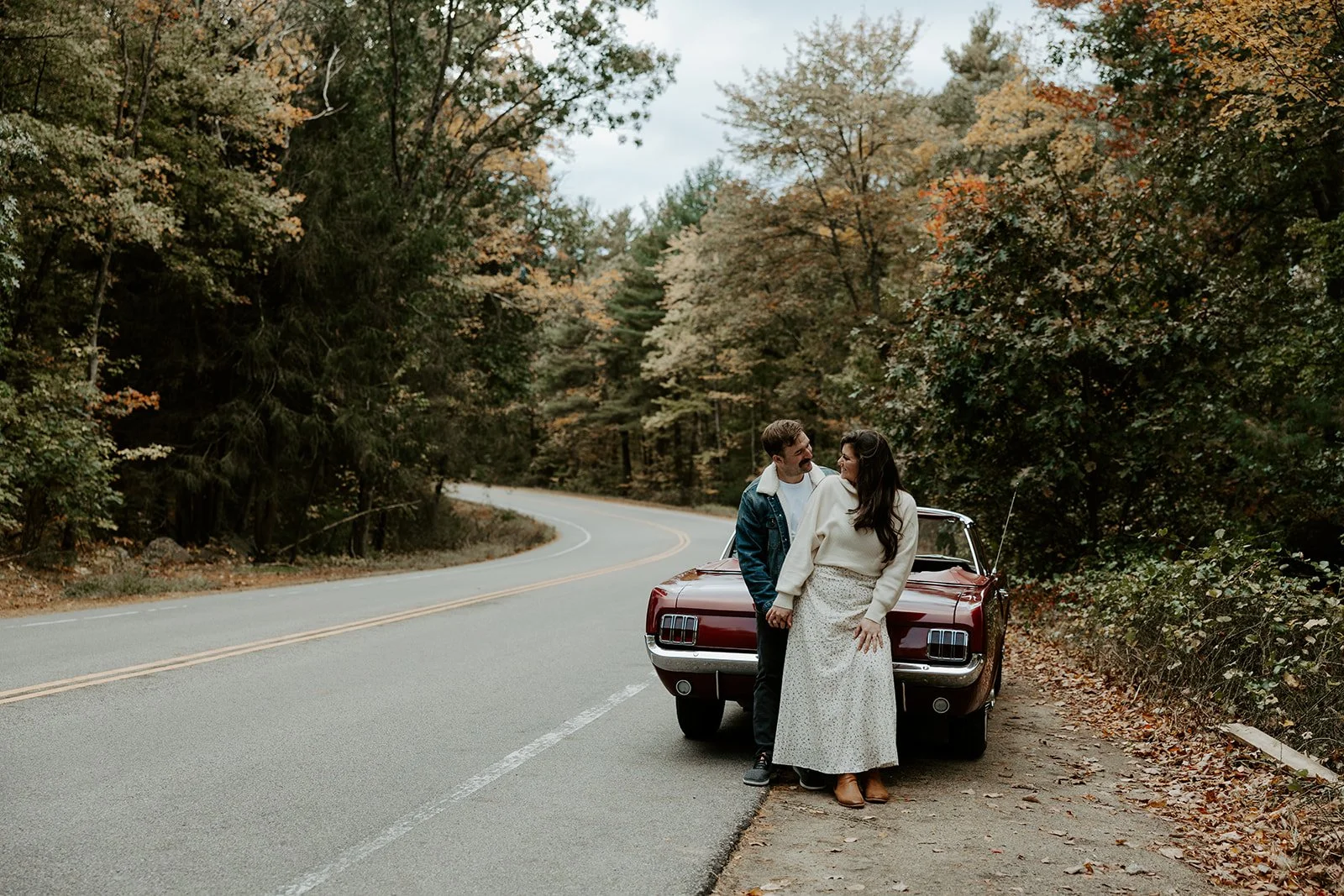 A couple taking vintage car engagement photos