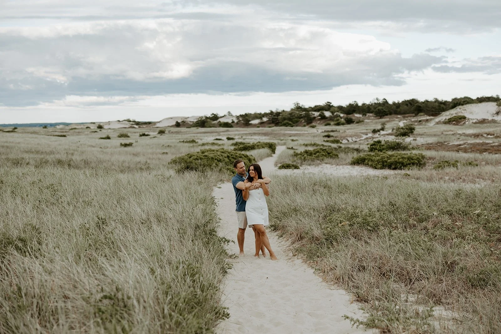 A couple posing for photos at their beach Massachusetts engagement photo location