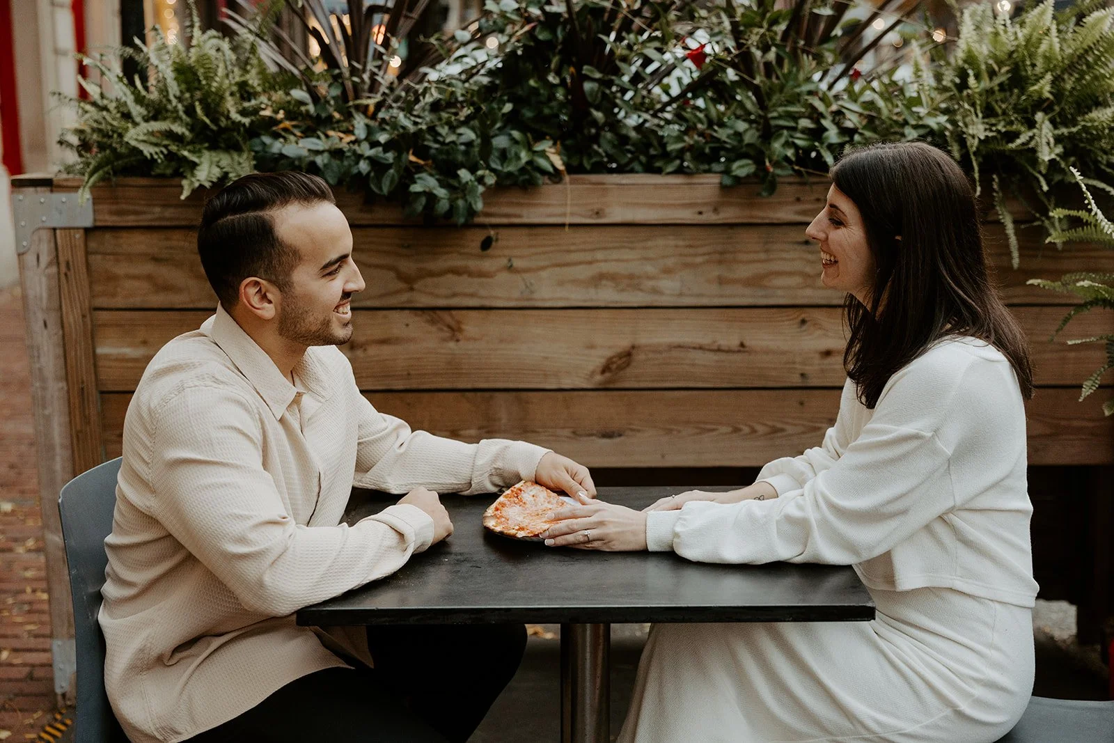 A couple taking date night engagement photos at a pizza place